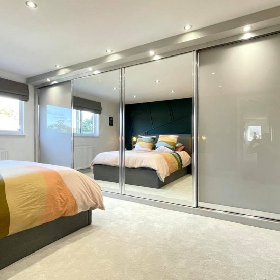 Light Grey & Mirror Sliding Wardrobes With Built in TV Unit by James Kilner in Wakefield