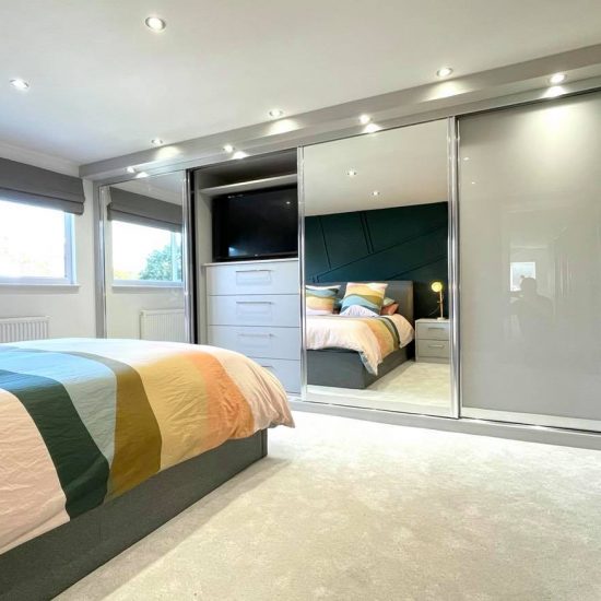 Light Grey & Mirror Sliding Wardrobes With Built in TV Unit by James Kilner in Wakefield